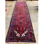 A North West Persian red ground hall carpet, 440 x 115cm