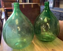 A pair of green glass carboys, height 64cm