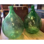 A pair of green glass carboys, height 64cm