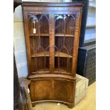 A Georgian style mahogany floor-standing corner display cabinet,having concave front, fitted a pair