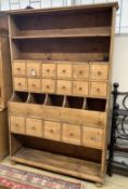 A Victorian pine grocer's shop cabinet,fitted seventeen drawers and open shelves, on bun feet,