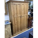 A panelled pine two door wardrobe, length 124cm, depth 59cm, height 197cm