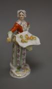 A late Meissen porcelain figure of a girl selling apples,polychrome-decorated, on scrolled base,H