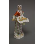 A late Meissen porcelain figure of a girl selling apples,polychrome-decorated, on scrolled base,H