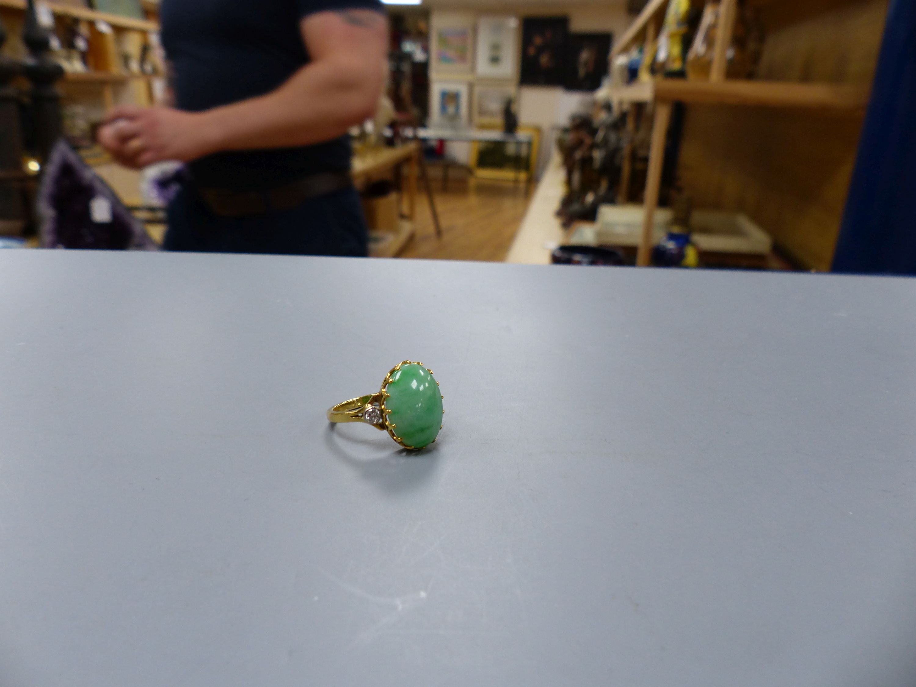 A jade and diamond dress ring, 18ct yellow gold setting,the oval cabochon jade flanked by two small - Image 2 of 3