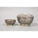 An Indonesian embossed white metal bowl and cover and two similar smaller bowls, largest diameter