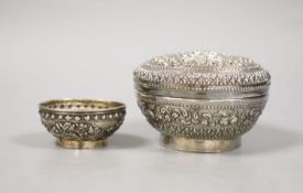 An Indonesian embossed white metal bowl and cover and two similar smaller bowls, largest diameter