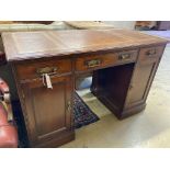 An Edwardian mahogany kneehole desk,fitted brown leather skiver over three frieze drawers and two