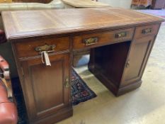 An Edwardian mahogany kneehole desk,fitted brown leather skiver over three frieze drawers and two