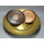 A Hugh Wallace hammered copper dish, a Taunton brass alms dish and another hammered copper dish,