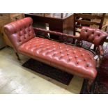 An Edwardian beech two-seater couch upholstered in buttoned burgundy hide on scrolled legs, length