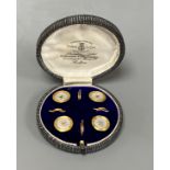 A cased set of four early 20th century 9ct and mother of pearl set buttons,gross weight 4 grams.