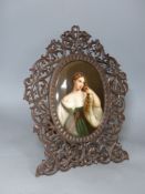 A large 19th century painted Paris porcelain plaque of a girl in a Black Forest carved frame,