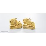 A pair of Etruscan style yellow metal recumbent lion pendant charms, 25mm, gross 11.1 grams.