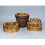 Two 19th century copper jelly moulds, and a wooden mortar, tallest 16cm