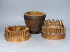 Two 19th century copper jelly moulds, and a wooden mortar, tallest 16cm
