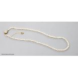 An early 20th century single strand cultured pearl and paste spacer necklace with diamond cluster