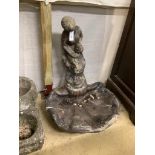 A reconstituted stone scallop shape bird bath with figural top (cracked), height 81cm