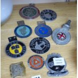 A small collection of car radiator caps and badges and motorcycle club badges