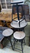 An adjustable wrought iron pub table and four matching telescopic stools