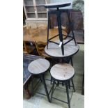 An adjustable wrought iron pub table and four matching telescopic stools