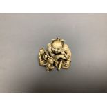 A Japanese ivory netsuke of two miniature men carrying a Samurai's tobacco pouch, Meiji period,