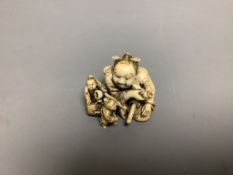 A Japanese ivory netsuke of two miniature men carrying a Samurai's tobacco pouch, Meiji period,