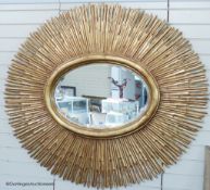 A large contemporary gilt oval 'sunburst' mirror, 145 cm wide, 130 cm highProvenance - a country