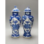 A pair of 19th century Chinese blue and white prunus vases and covers, height 38cm, a Kangxi marks