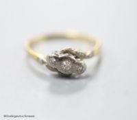 An 18ct & Pt, three stone diamond chip set crossover ring, size M, gross 2.5 grams.