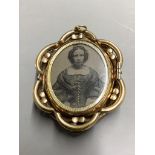 A Victorian pinchbeck and enamel revolving oval mourning brooch, with plaited hair below a glazed