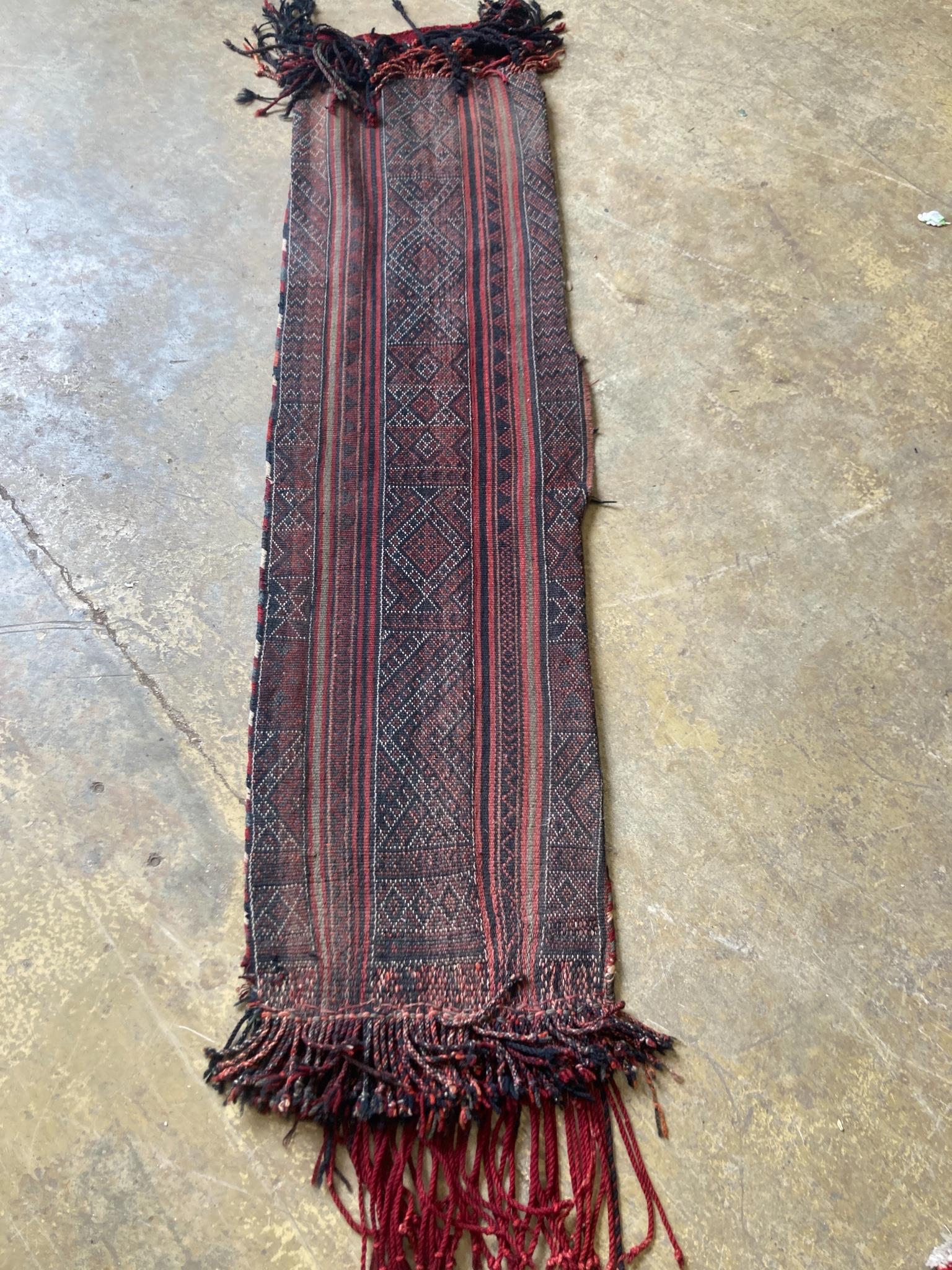 An Afghan saddle rug, 180 x 44cm