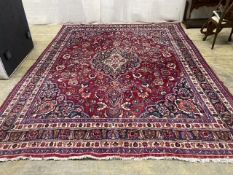 A Heriz style burgundy ground carpet, 380 x 360cm