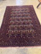 An Eastern dark red and blue ground carpet with central pole medallion within multi borders and