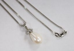 A modern 18ct white gold, cultured pearls and three stone diamond set pendant, 24mm, gross 2.4