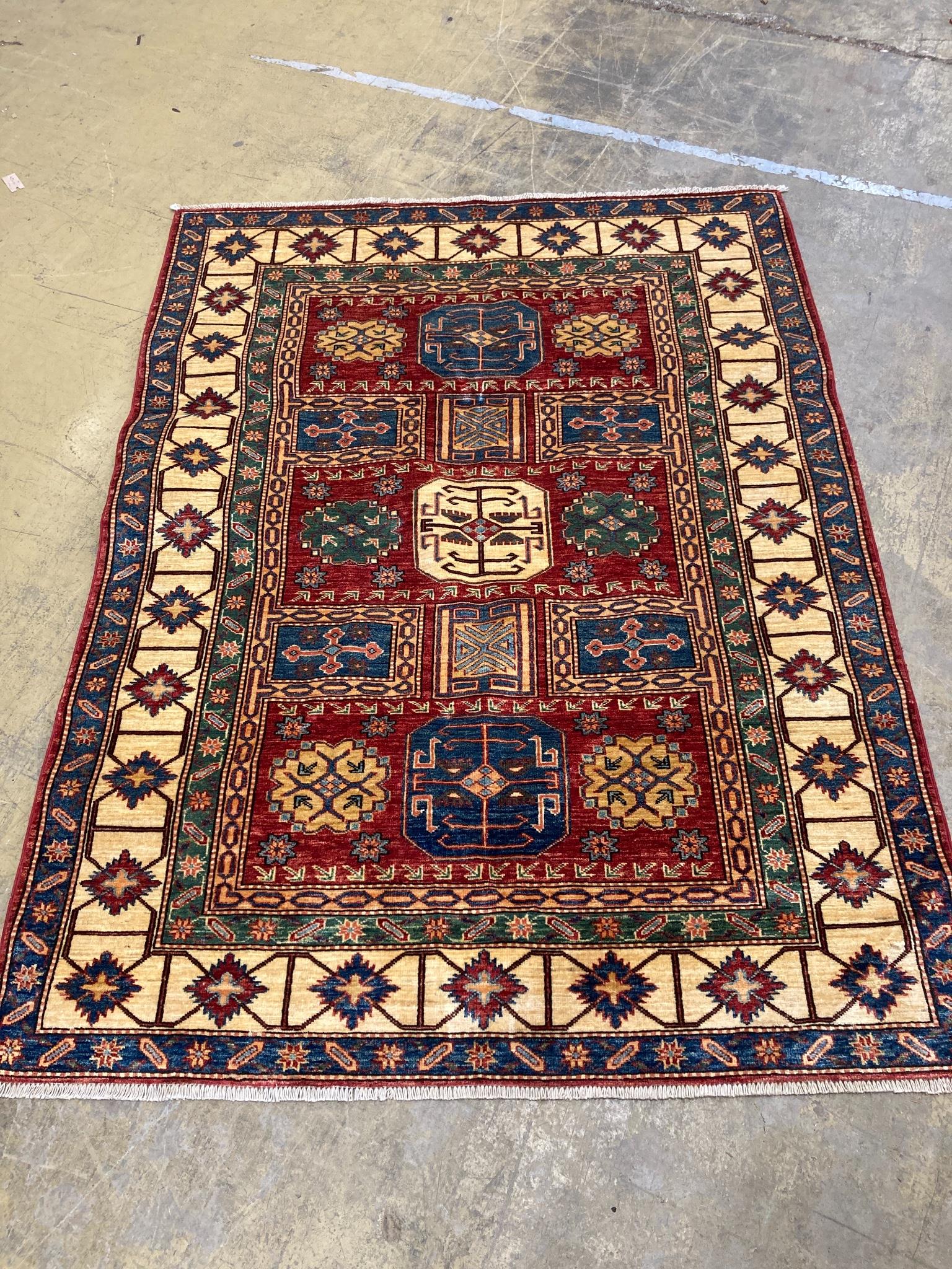 A Caucasian design red ground rug with geometric motifs within multi borders and guards, 200 x