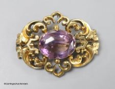 A cased late Victorian yellow metal and amethyst set pierced scroll brooch, 45mm,gross weight 10.6