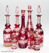 A collection of six Bohemian ruby flashed wheel engraved glass decanters, tallest 40cm, a similar