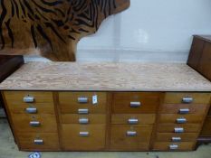 A mid century design 17 drawer teak habadashery cabinet with later top, width 174cm, depth 59cm,