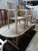 An oval weathered teak extending garden table, 240cm extended, width 100cm, height 74cm and eight