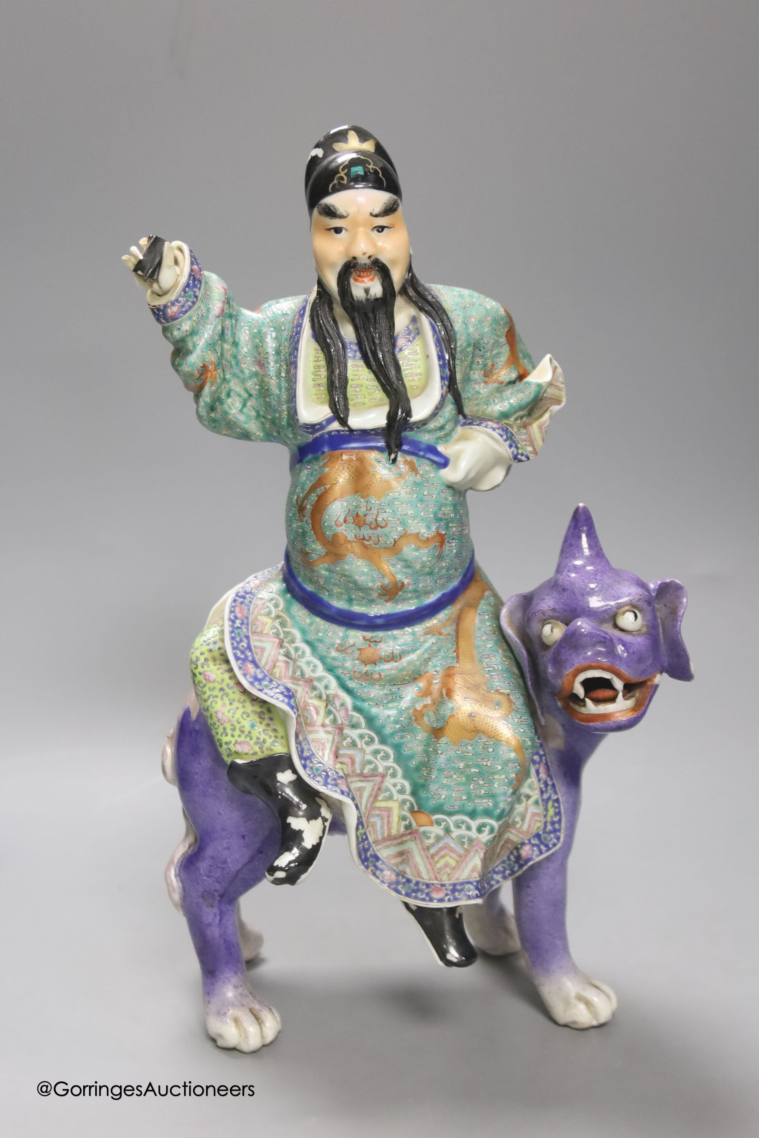 A Chinese enamelled porcelain figure group of an immortal on a mythical beast, Republic period,