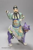 A Chinese enamelled porcelain figure group of an immortal on a mythical beast, Republic period,