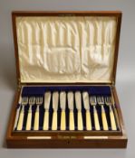 A cased set of twelve pairs of George V ivory handled silver fish eaters, Goldsmiths & Silversmiths