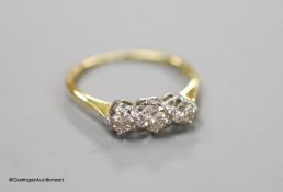 An 18ct and three stone diamond ring, size LM, gross 2.1 grams.