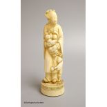 A Japanese ivory okimono of a lady feeding a child, Meiji period, height 18cm