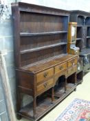 A late 18th/early 19th century oak dresser,having two-tier boarded plate rack over five drawers and