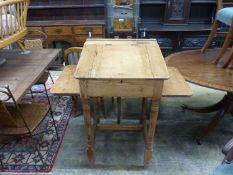 A Victorian pine clerk's desk,with sloping top, side flaps and brass inkwell, on turned supports,