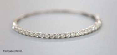 A modern 18ct white gold and twenty three stone diamond set hinged bracelet, gross 9.2 grams,each