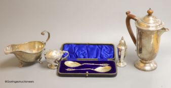 A cased pair of ornate Edwardian silver preserve spoons, Sheffield, 1905, a silver sauceboat, a
