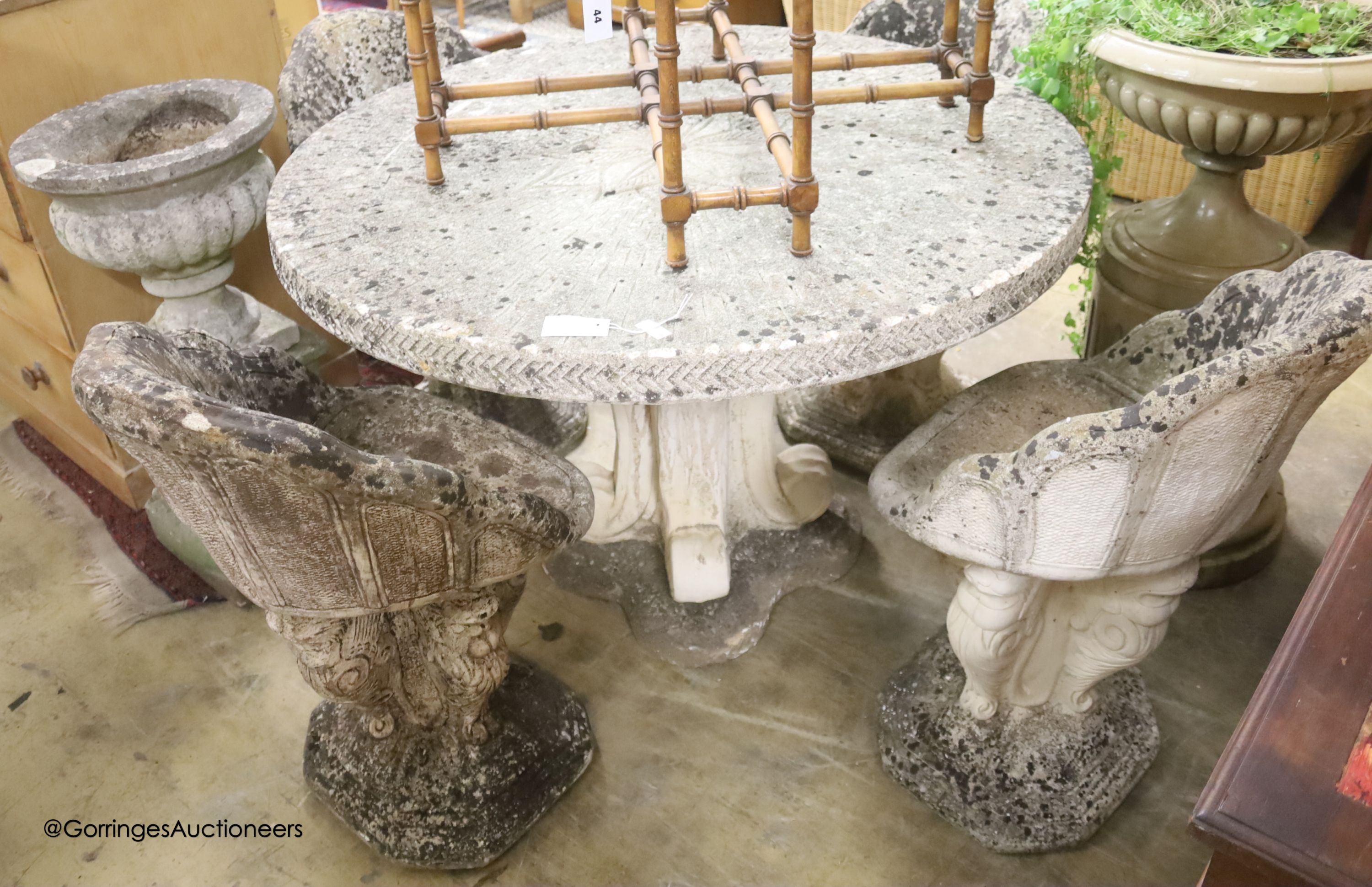 A circular reconstituted stone circular garden table, diameter 114cm, height 79cm and four matching